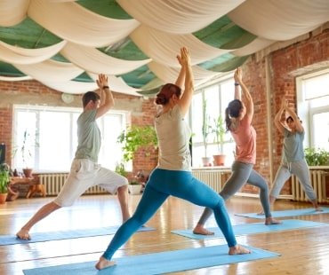 group-of-people-doing-yoga-warrior-pose-at-studio.jpg